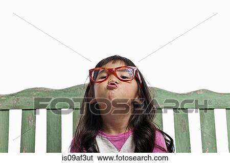 Stock Photograph - Studio portrait of young girl with puckered lips. Fotosearch