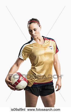 Stock Photograph - Studio shot of young female soccer player holding ball. Fotosearch