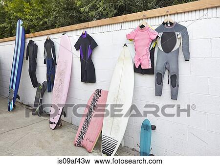 Surfboards and skateboards leaning against wall, and wetsuits hanging View Large Photo Image Stock Photo - Surfboards and skateboards leaning against wall, and wetsuits hanging. Fotosearch