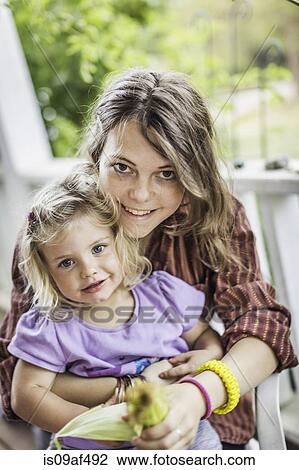 Teenage girl and baby girl smiling View Large Photo Image Stock Image - Teenage girl and baby girl smiling. Fotosearch