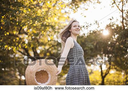 Teenage girl holding sunhat running in park View Large Photo Image Stock Image - Teenage girl holding sunhat running in park. Fotosearch