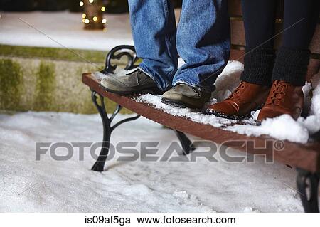 The legs of young couple standing on top of snow covered park bench View Large Photo Image Stock Image - The legs of young couple standing on top of snow covered park bench. Fotosearch