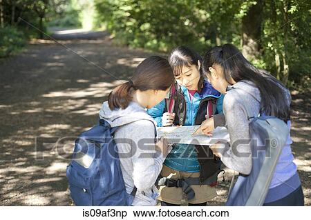 Three young female hikers looking at map View Large Photo Image Stock Photography - Three young female hikers looking at map. Fotosearch