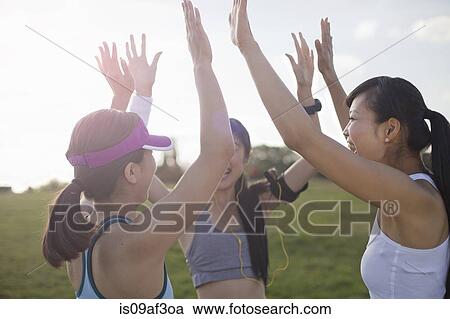 Stock Image - Three young female runners preparing to run. Fotosearch