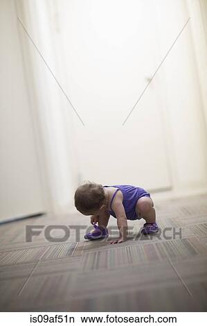 Picture - Toddler girl crouching on floor. Fotosearch
