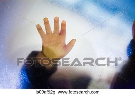 Stock Image - Toddler girl's hand touching glass. Fotosearch