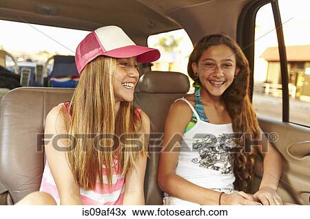 Two girls sitting in car smiling View Large Photo Image Stock Photo - Two girls sitting in car smiling. Fotosearch