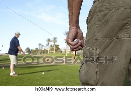 Two male golfers taking shot on green View Large Photo Image Stock Photo - Two male golfers taking shot on green. Fotosearch