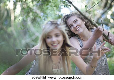 Stock Photograph - Two teenage girls discovering woodland. Fotosearch