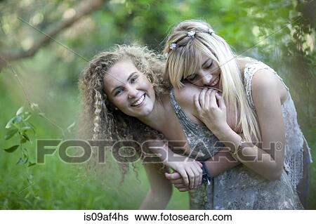 Stock Photograph - Two teenage girls having fun in woodland. Fotosearch