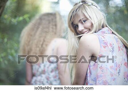 Stock Image - Two teenage girls strolling in woodland. Fotosearch