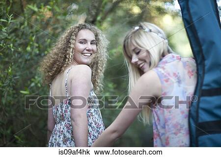 Stock Image - Two teenage girls walking in woodland. Fotosearch