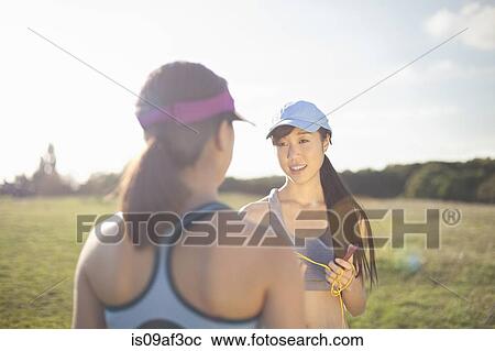 Stock Image - Two young female runners chatting. Fotosearch