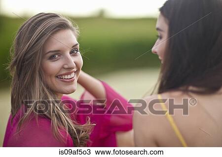 Stock Image - Two young women at riverside. Fotosearch