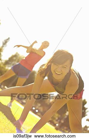 Two young women exercising in park View Large Photo Image Stock Photo - Two young women exercising in park. Fotosearch