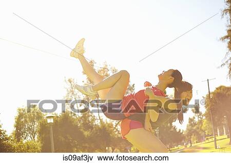 Two young women having fun in park View Large Photo Image Stock Photo - Two young women having fun in park. Fotosearch