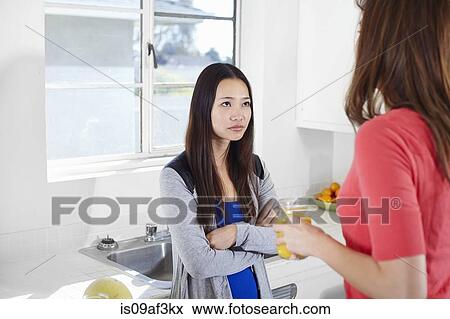 Two young women in kitchen having an argument View Large Photo Image Stock Photo - Two young women in kitchen having an argument. Fotosearch
