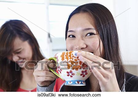 Two young women in kitchen having coffee break View Large Photo Image Stock Image - Two young women in kitchen having coffee break. Fotosearch