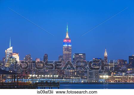 View of waterfront and New York skyline at dusk View Large Photo Image Stock Image - View of waterfront and New York skyline at dusk. Fotosearch