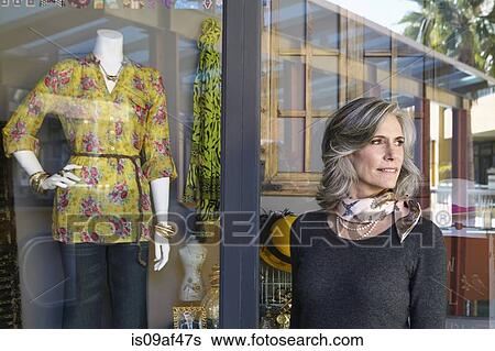 Woman standing outside shop window View Large Photo Image Stock Photograph - Woman standing outside shop window. Fotosearch