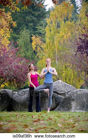 Yoga instructor teaching young woman in forest View Large Photo Image Stock Image - Yoga instructor teaching young woman in forest. Fotosearch