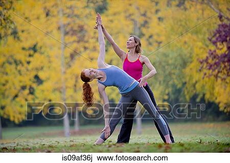 Yoga instructor teaching young woman in forest View Large Photo Image Stock Image - Yoga instructor teaching young woman in forest. Fotosearch