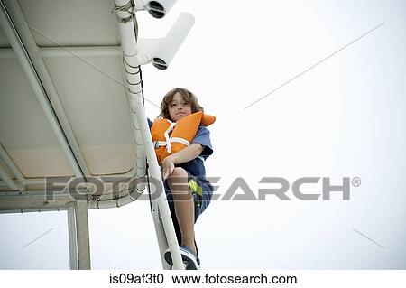 Young boy in life jacket climbing up boat steps View Large Photo Image Stock Image - Young boy in life jacket climbing up boat steps. Fotosearch