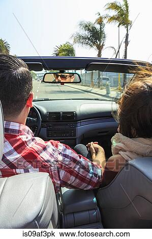 Stock Image - Young couple driving convertible, San Diego, California, USA. Fotosearch