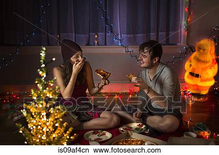 Young couple enjoying pizza at christmas View Large Photo Image Picture - Young couple enjoying pizza at christmas. Fotosearch