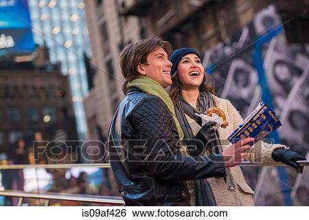 Stock Photograph - Young couple on vacation with map and bagel, New York City, USA. Fotosearch