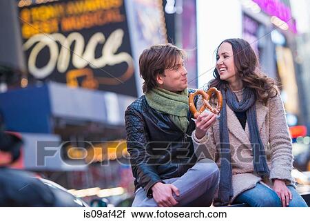 Stock Image - Young couple sharing pretzel, New York City, USA. Fotosearch