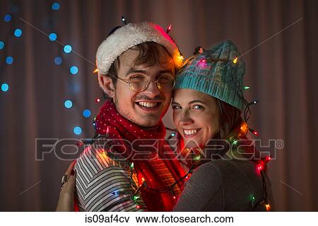 Young couple wrapped in decorative lights at christmas View Large Photo Image Stock Photo - Young couple wrapped in decorative lights at christmas. Fotosearch