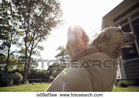 Young girl hugging pet labrador in garden View Large Photo Image Stock Photo - Young girl hugging pet labrador in garden. Fotosearch