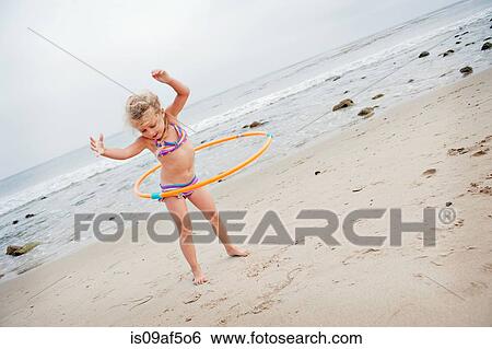 Young girl with hoolahoop on the beach View Large Photo Image Stock Photograph - Young girl with hoolahoop on the beach. Fotosearch