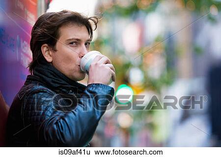 Stock Photograph - Young male tourist drinking coffee, New York City, USA. Fotosearch
