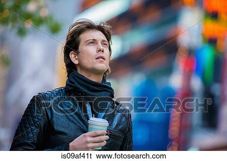Stock Photograph - Young male tourist with takeaway coffee, New York City, USA. Fotosearch