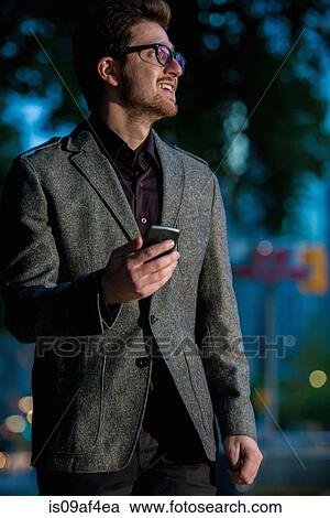 Young man strolling down street with mobile phone, Toronto, Ontario, Canada View Large Photo Image Stock Image - Young man strolling down street with mobile phone, Toronto, Ontario, Canada. Fotosearch
