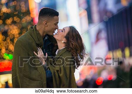 Stock Photography - Young tourist couple wrapped in blanket, New York City, USA. Fotosearch