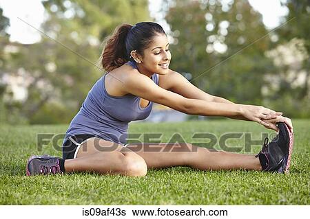 Stock Photograph - Young woman doing stretching exercise. Fotosearch