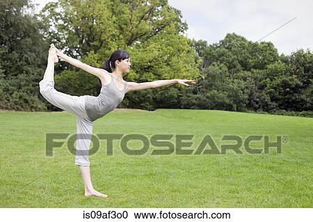 Young woman in park practicing yoga king dancer pose View Large Photo Image Stock Image - Young woman in park practicing yoga king dancer pose. Fotosearch