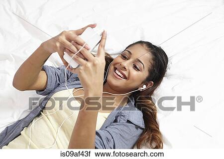 Young woman listening to music in bedroom View Large Photo Image Stock Image - Young woman listening to music in bedroom. Fotosearch
