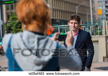 Young woman photographing boyfriend View Large Photo Image Stock Image - Young woman photographing boyfriend. Fotosearch