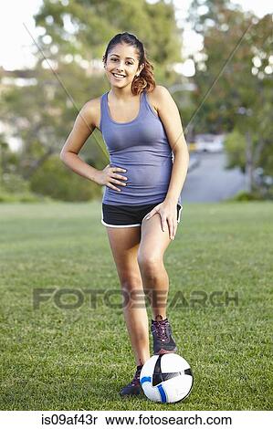 Stock Photography - Young woman posing with football. Fotosearch
