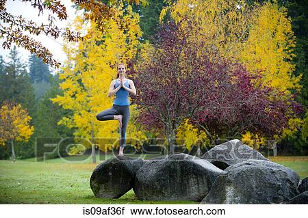 Young woman practising yoga on rock View Large Photo Image Stock Image - Young woman practising yoga on rock. Fotosearch
