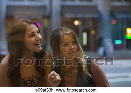 Stock Image - Young women window shopping. Fotosearch