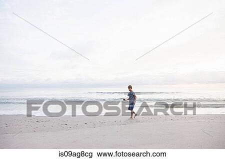 Boy playing on beach View Large Photo Image Stock Image - Boy playing on beach. Fotosearch