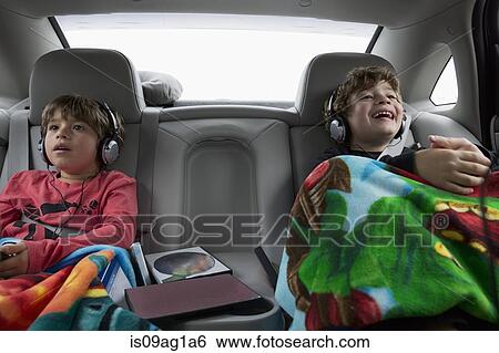 Brothers in back seat of car, wearing headphones View Large Photo Image Stock Photograph - Brothers in back seat of car, wearing headphones. Fotosearch