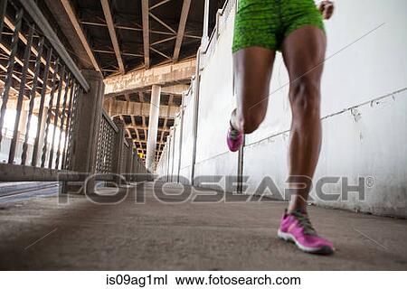 Cropped shot of young woman running on city bridge View Large Photo Image Stock Image - Cropped shot of young woman running on city bridge. Fotosearch