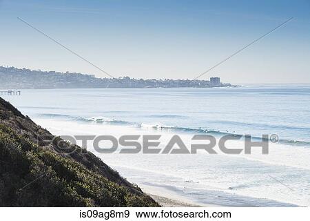 Stock Photo - Distant view of surfers at sea, Black Beach, La Jolla, California, USA. Fotosearch