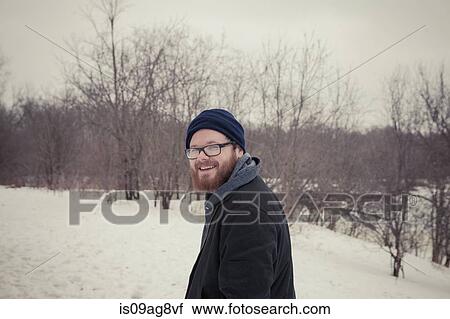 Stock Image - Portrait of young man out walking in snow. Fotosearch